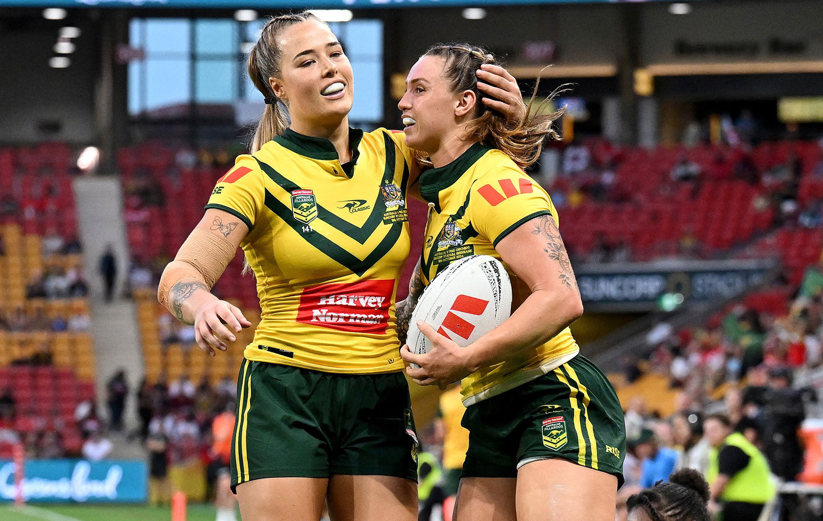 Isabelle Kelly hugs Julia Robinson after a try for Australia against PNG.