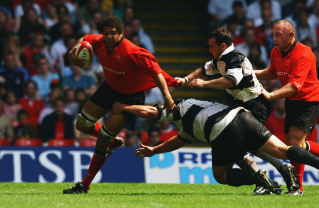 Colin Charvis evades the tackles of two Barbarians players