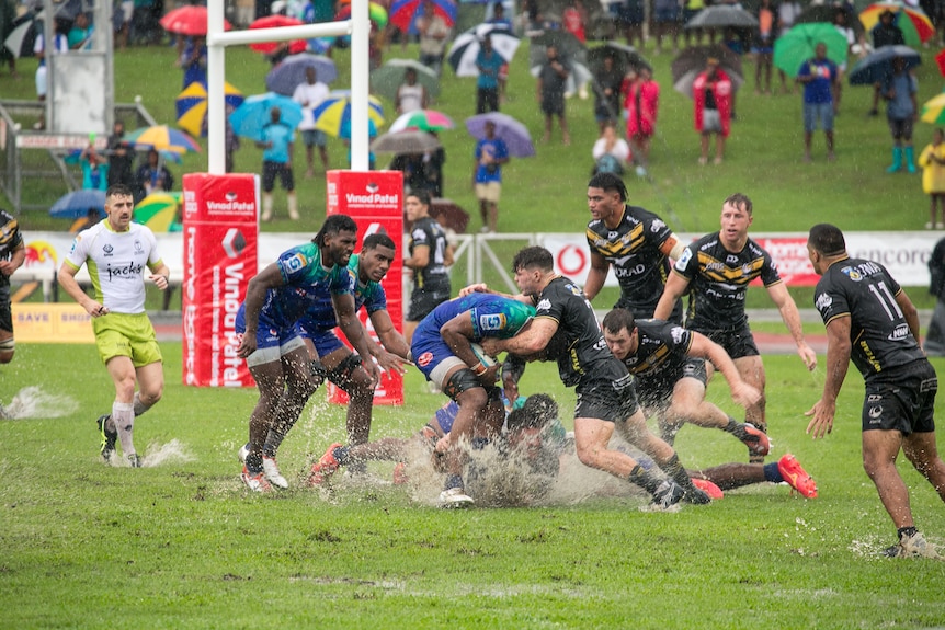 It's a wet day, Frank is amongst a rugby game with splashes of muddy water coming up. 