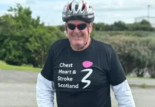 Scottish Rugby Ken MacAulay is wearing a black t-shirt  over a white cycling shirt. The shirt has the words 