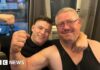 Kane Forder with his dad David both wearing black and with an arm raised in a flexing position
