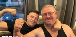 Kane Forder with his dad David both wearing black and with an arm raised in a flexing position