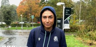 Emma Wassell, wearing a Scotland rugby hoodie, smiling at the camera