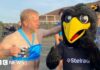 A man with a beer dressed as Princess Jasmine larking about with a person dressed as a giant black bird