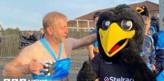 A man with a beer dressed as Princess Jasmine larking about with a person dressed as a giant black bird