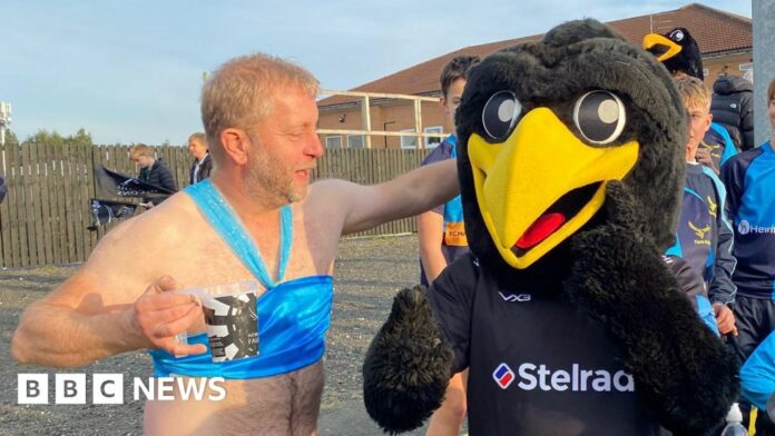 A man with a beer dressed as Princess Jasmine larking about with a person dressed as a giant black bird