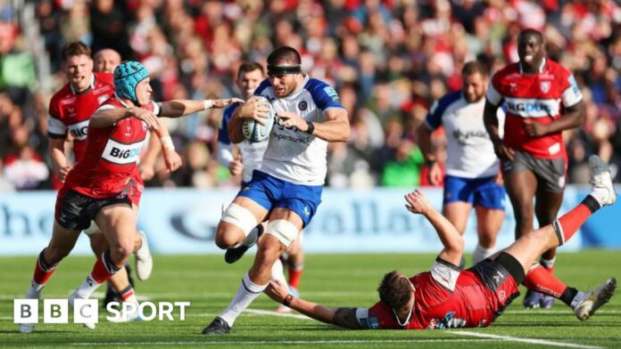 Josh Bayliss barges through a tackle with the ball