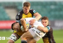 Andre Esterhuizen of Hollywoodbets Sharks is tackled by Harry Wilson of Dragons and Shane Lewis-Hughes of Dragons 