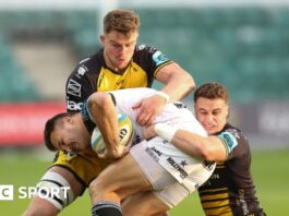 Andre Esterhuizen of Hollywoodbets Sharks is tackled by Harry Wilson of Dragons and Shane Lewis-Hughes of Dragons 