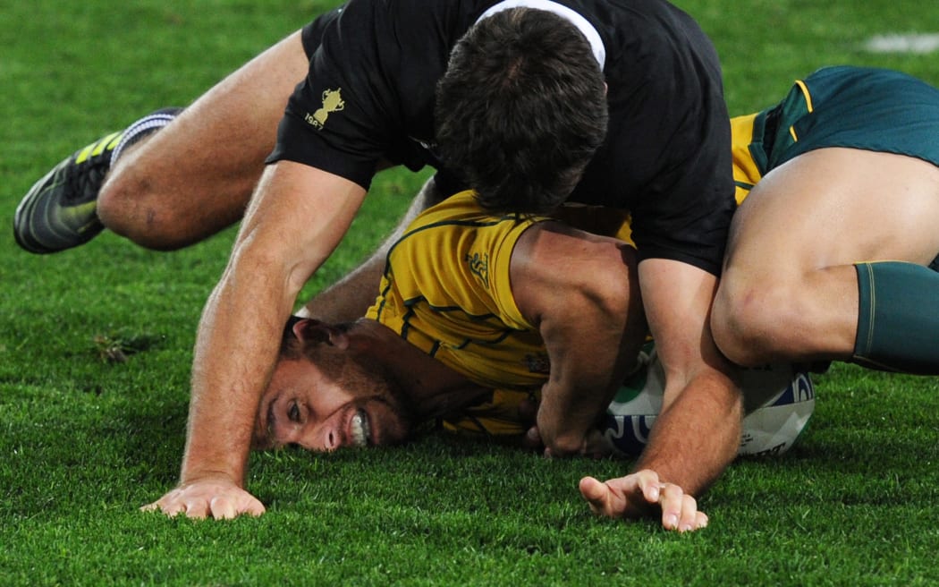 Richard Kahui tackles Quade Cooper during the All Blacks v Australia Semi-Final match of the 2011 Rugby World Cup.