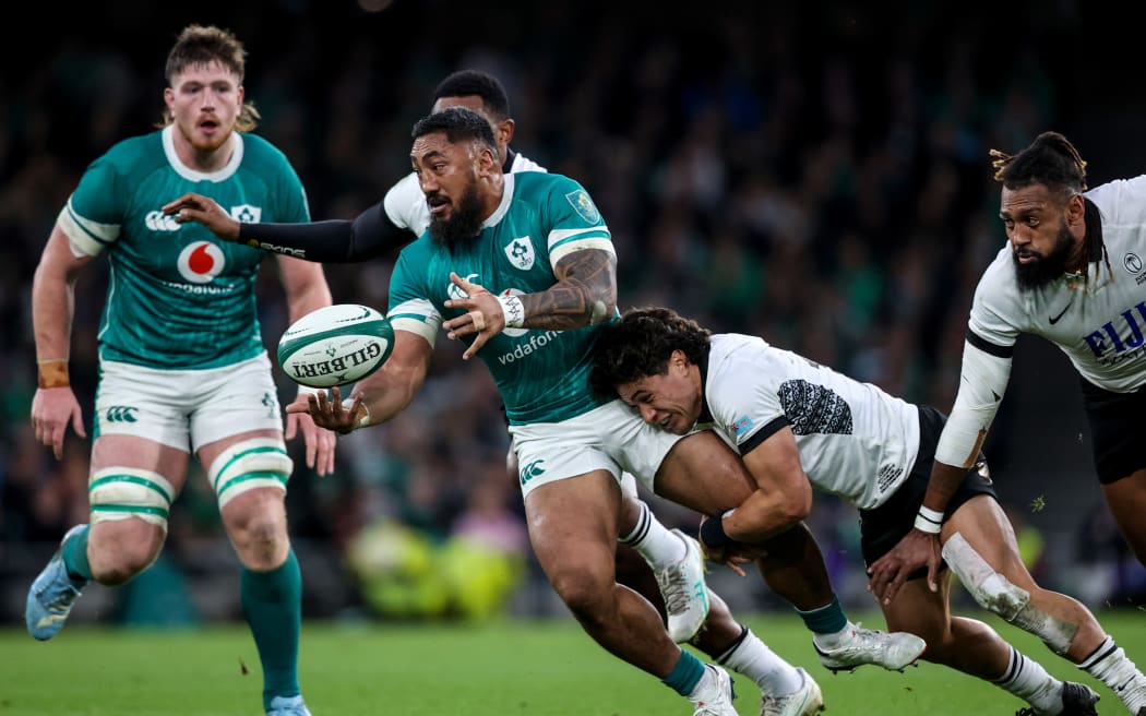 Ireland's Bundee Aki is tackled by Fiji's Caleb Muntz.