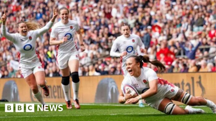 A woman in white England kit looks thrilled as she scores a rugby try with three other England players behind her looking equally happy