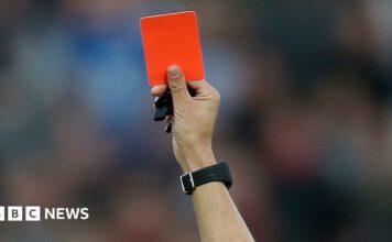 A red card is held up (stock image).