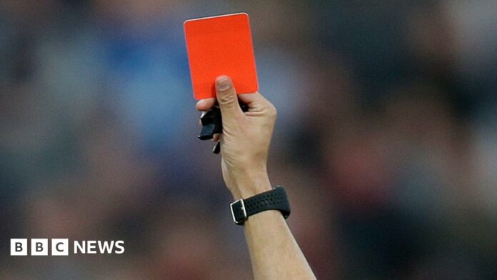 A red card is held up (stock image).