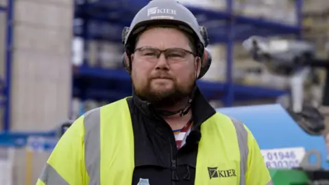 PPP Carl Walmsley at work at Sellafield is wearing a hi-vis jacket yellow jacket and hard hat.