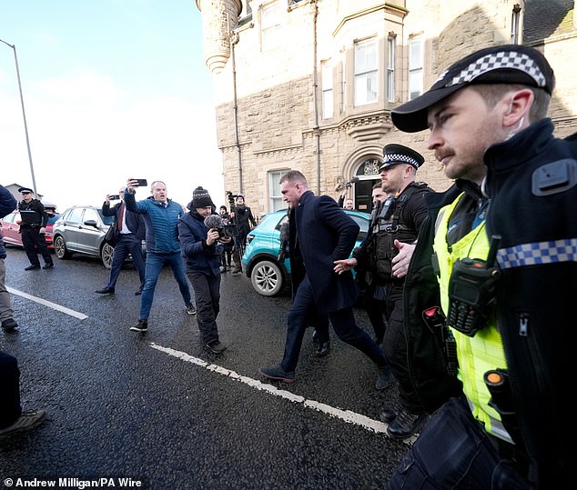 Hogg leaves Selkirk Sheriff Court on Thursday surrounded by police as he is questioned by members of the press