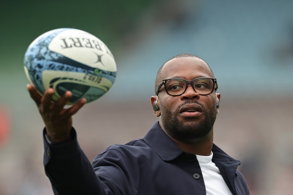 Ugo Monye, former England rugby international and TNT presenter, holding a rugby ball.