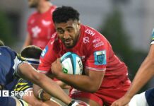 Carwyn Tuipulotu goes into a tackle with the ball during a game for Scarlets last season