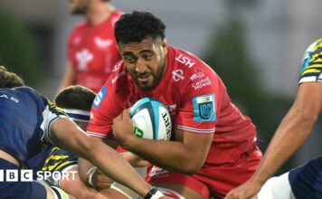 Carwyn Tuipulotu goes into a tackle with the ball during a game for Scarlets last season