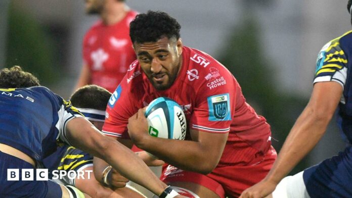 Carwyn Tuipulotu goes into a tackle with the ball during a game for Scarlets last season