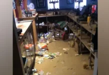 BBOB Rugby Club Flood waters in a bar with bottles and crisp packets floating in the brown water.