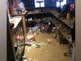 BBOB Rugby Club Flood waters in a bar with bottles and crisp packets floating in the brown water.