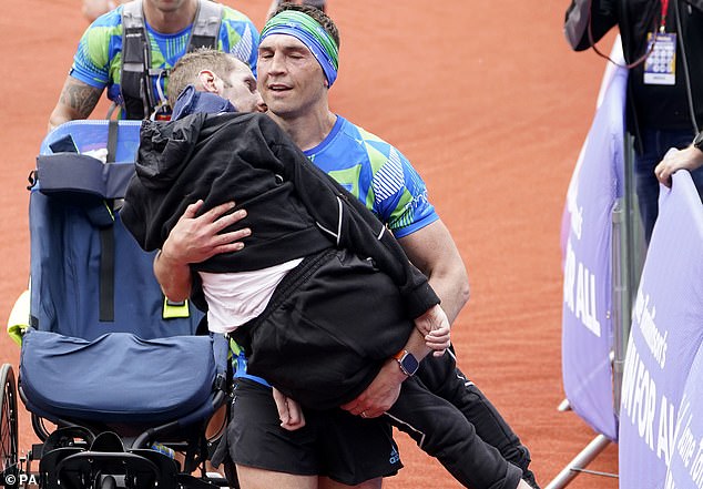 Kevin Sinfield is pictured carrying his friend the late Rob Burrow over the finish line before he passed away