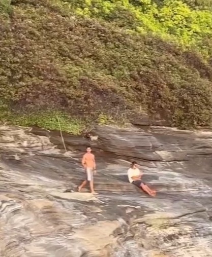 Two men on a rocky cliff before a fatal jump.