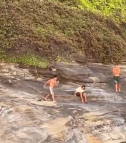 A man jumping from a cliff into the water.