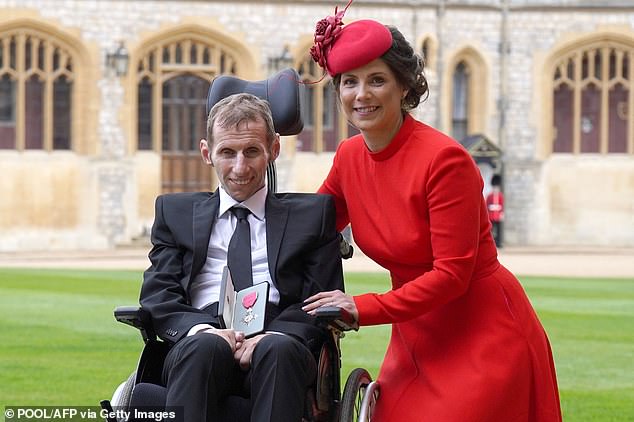 Former rugby league player Rob Burrow and his wife Lindsey pose for a photograph with his medal after he was awarded his MBE at Windsor Castle in 2022