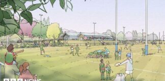 An artist impression of the proposed rugby ground with drawings of spectators and people playing rugby. There are trees in the background and two clubhouse buildings