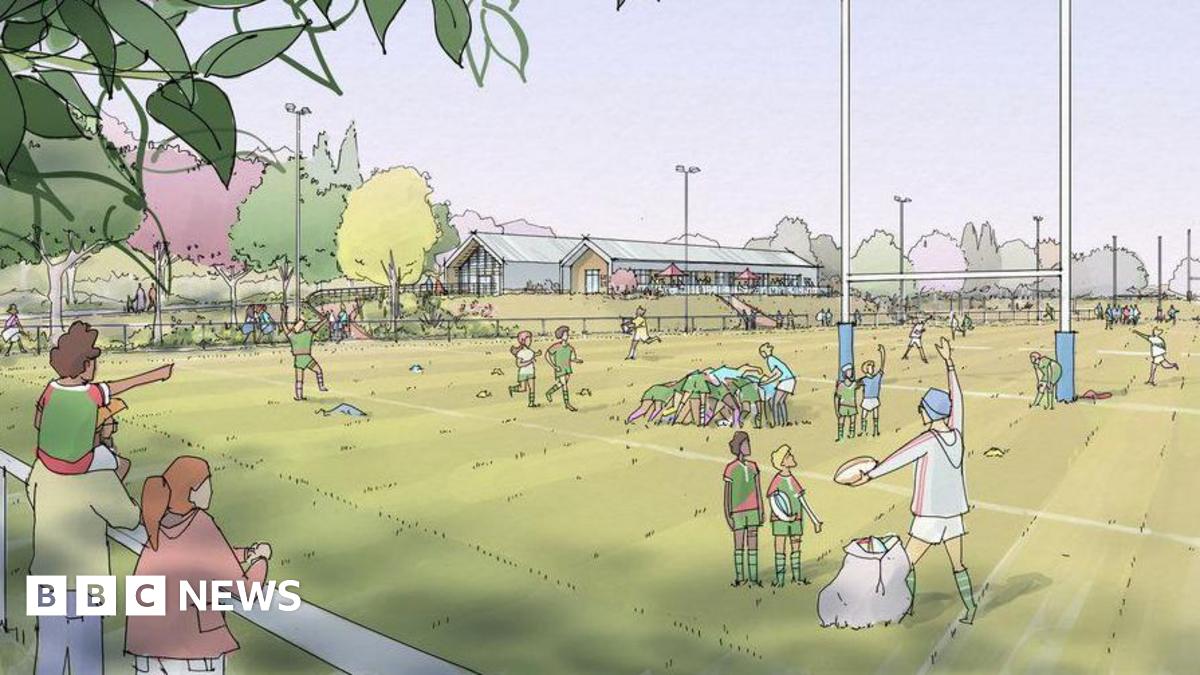 An artist impression of the proposed rugby ground with drawings of spectators and people playing rugby. There are trees in the background and two clubhouse buildings