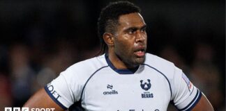 Viliame Mata stands with his hands on his hips