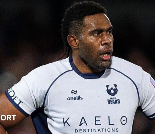 Viliame Mata stands with his hands on his hips