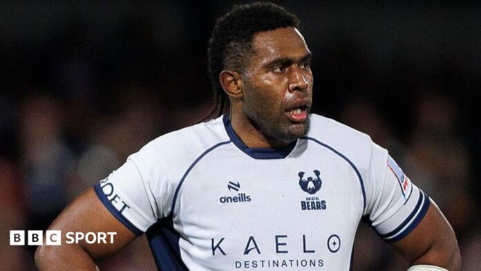 Viliame Mata stands with his hands on his hips